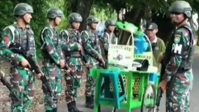 Kocak, Penjual Es Dawet Santuy Lewat di Depan TNI yang Tengah Baris